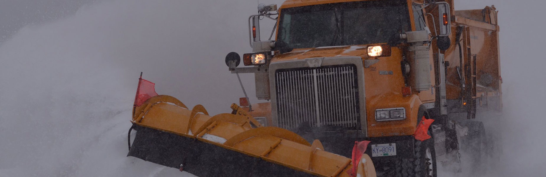 Snow plow truck clearing a commercial property